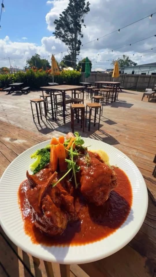 Braised lamb shanks with carrots, broccoli and mash on the outdoor deck