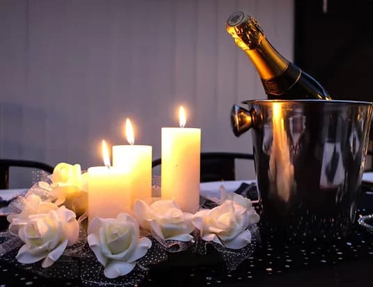 Champagne bucket, candles and roses on a function table at Three Furlongs