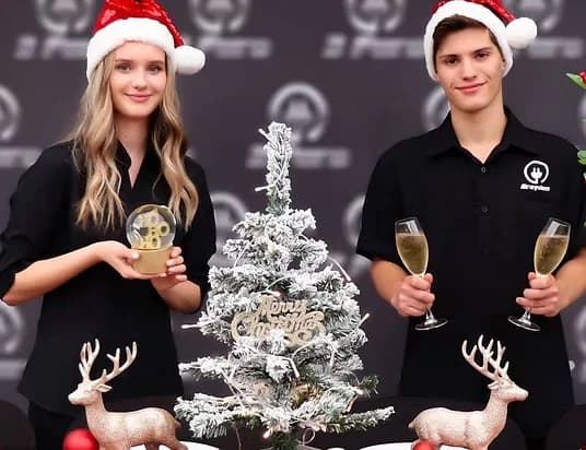 Three Furlongs staff at a Christmas function with branded backdrop