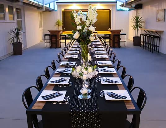 Long banquet table set for an evening function at Three Furlongs