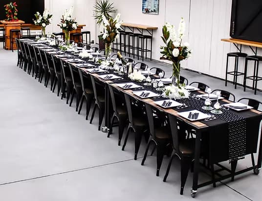 Long banquet table set for a function indoors at Three Furlongs