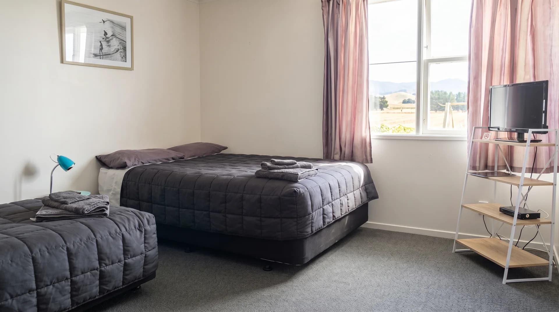 A guest room at Three Furlongs with a queen and single bed